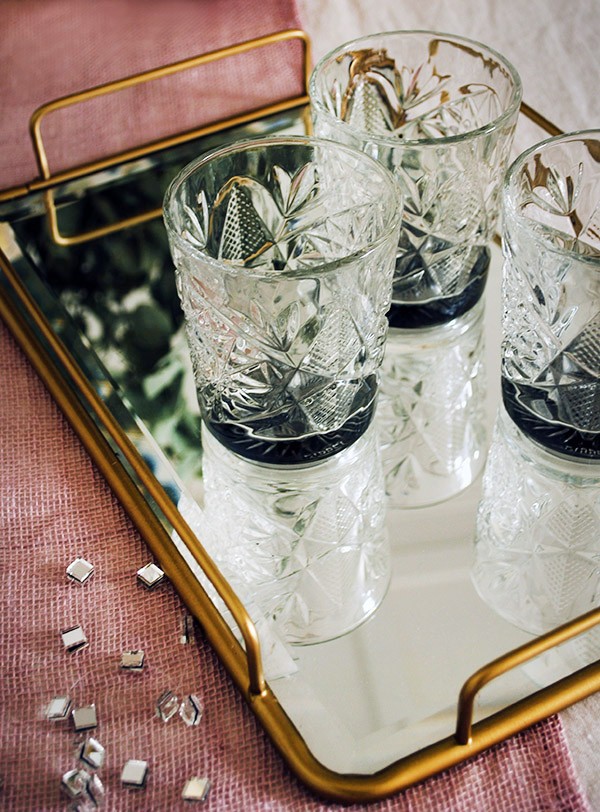 Serve your drinks on a mirror-topped tray for a dash of festive flair. West Elm's Fishs Eddy brass mirror topped tray.