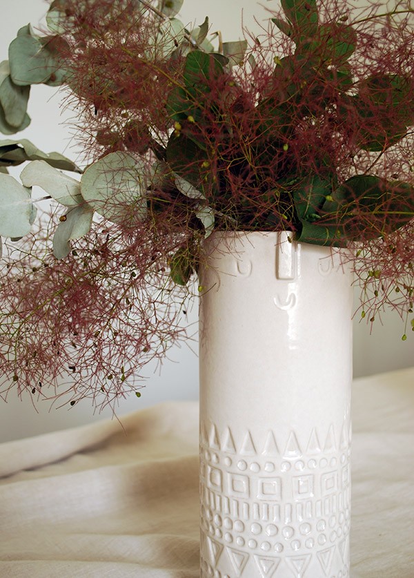 We created a beautiful centrepiece with a mid-century style vase. West Elm's Atelier Stella vase is perfect, and we filled it with dusky pink smoke bush and eucalyptus leaves.