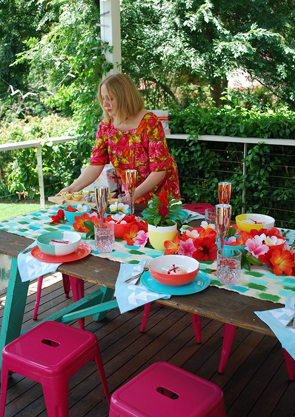 A tropical Christmas table setting - with a handpainted table runner adorned with hibiscus, frangipani and a monstera chandelier. Photo by Lisa Tilse for We Are Scout.