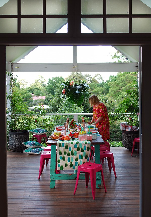 A tropical Christmas table setting - with a handpainted table runner adorned with hibiscus, frangipani and a monstera chandelier. Photo by Lisa Tilse for We Are Scout.