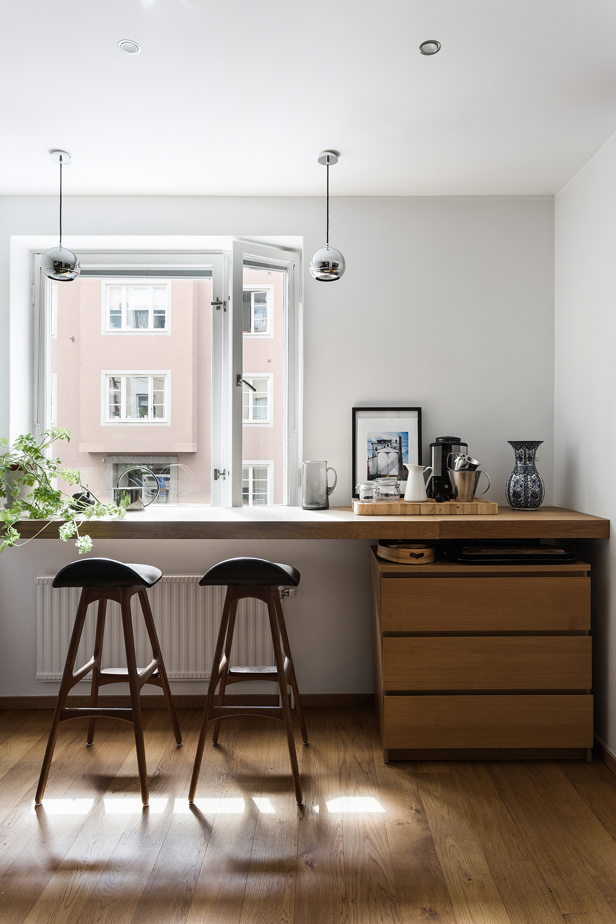 An elegant black kitchen with a cafe-style eating space - We Are Scout