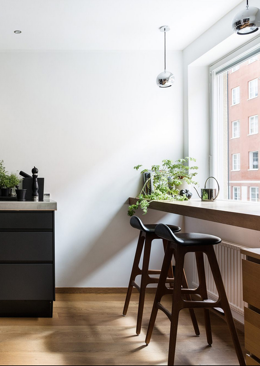 An elegant black kitchen with a cafe-style eating space - We Are Scout