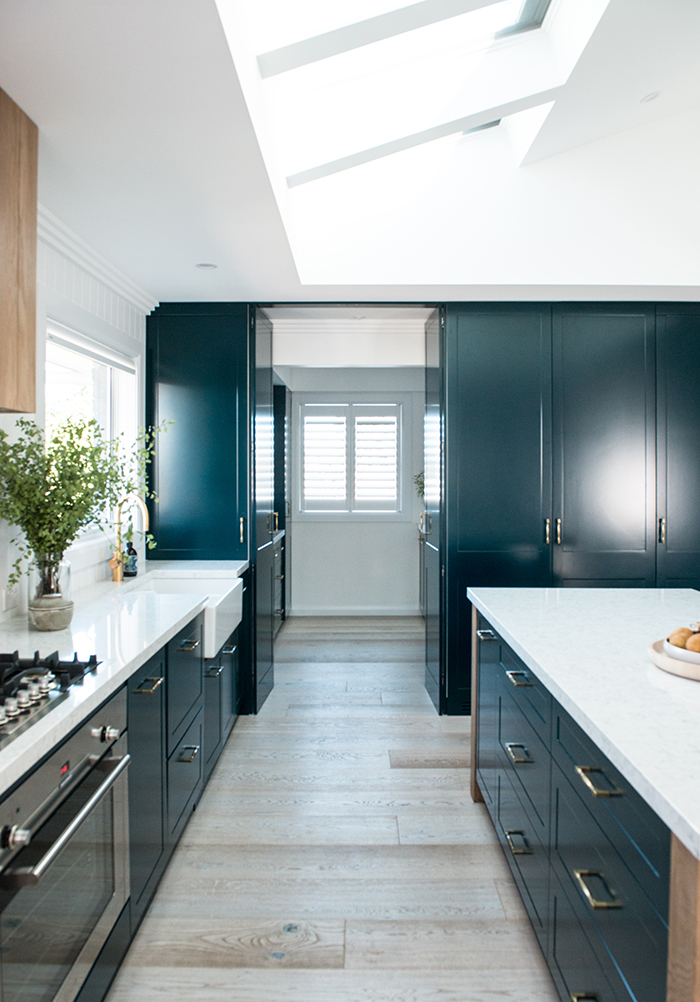 Modern beach house - teal kitchen and concealed laundry