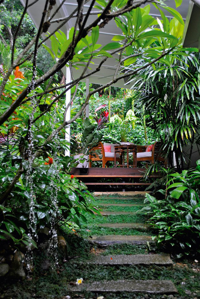 A lush and tropical garden creates a relaxed welcome to this home. Photo via Queensland Homes.